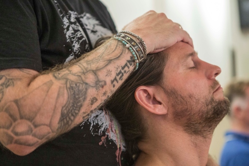 man leunt achterover tegen andere man